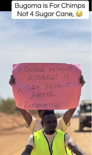 A photo of two men. One man holds a sign.